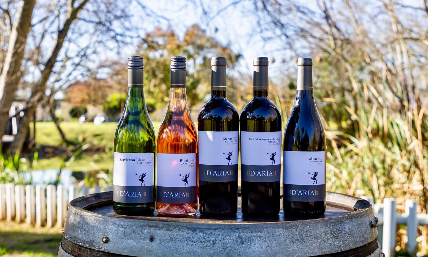 Range of D'Aria Wines sitting on a wine barrel