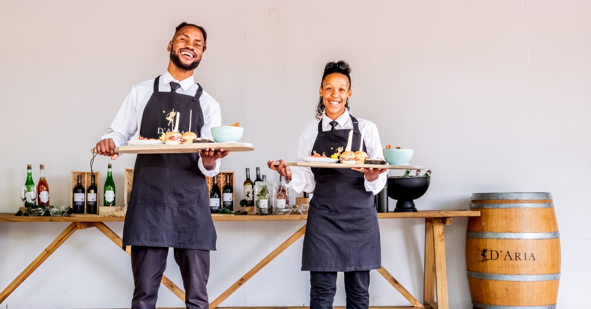 D'Aria Staff smiling and holding food trays