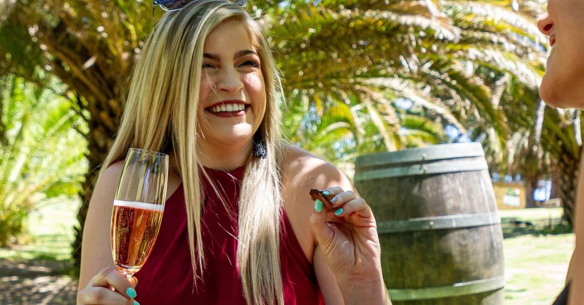 a person drinking a glass of sparkling rose wine