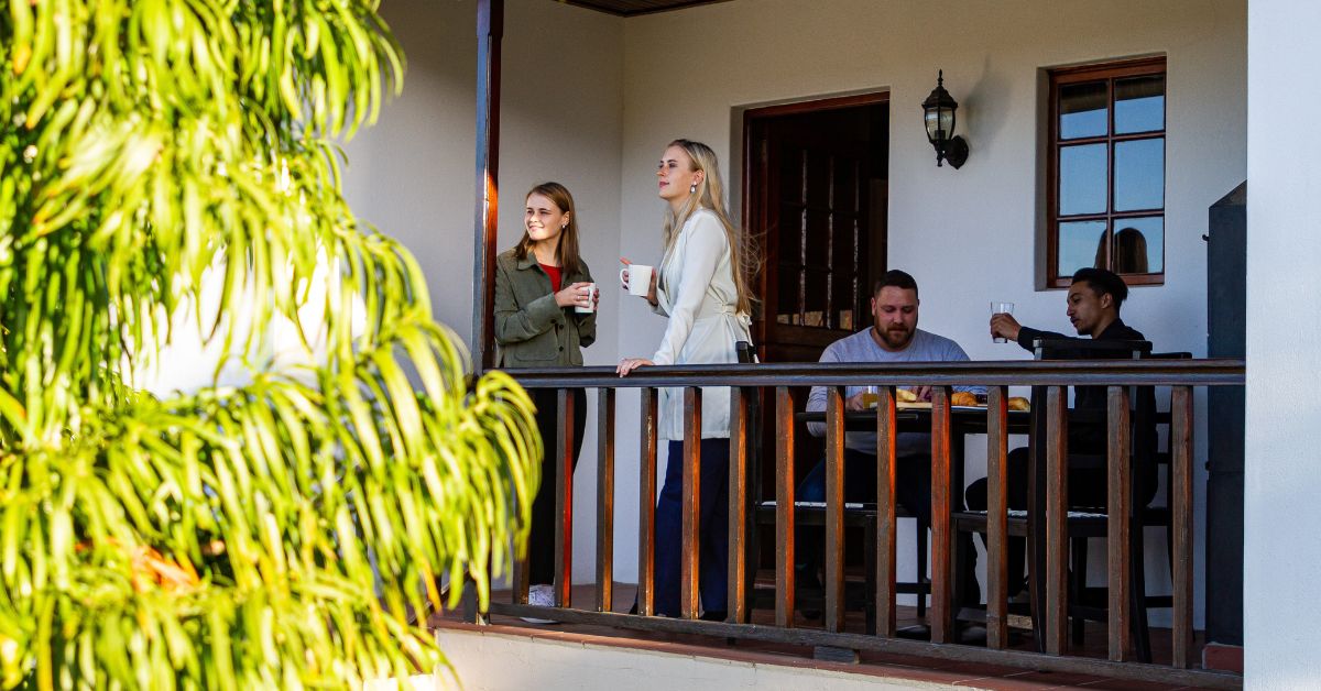 Friends on the balcony of a wine farm accommodation