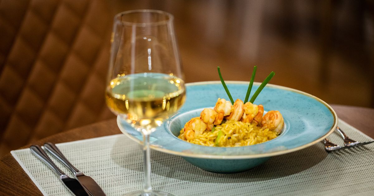 food and wine pairing - Seafood risotto and white wine on a table