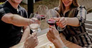 People clinking glasses of wine in celebration at D'aria