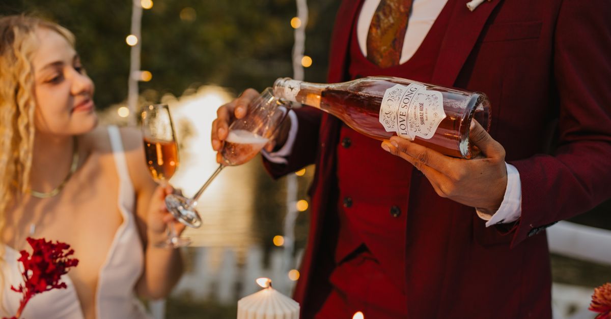Person pouring a bottle of D'Aria's Love Song for a bride