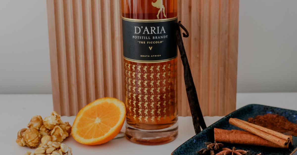 D'Aria The Piccolo with some ingredients in front of it like oranges and cinnamon sticks