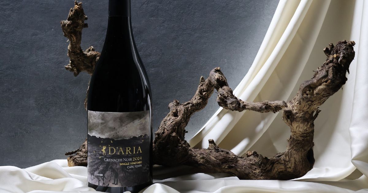 D'Aria Grenache Noir in a setting with wood and white silk drapes
