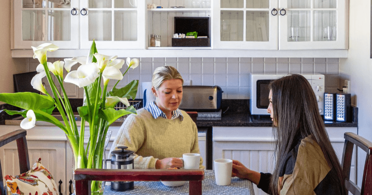 Two women enjoying a cup of coffee at D'Aria's Wineries Cottage accommodation