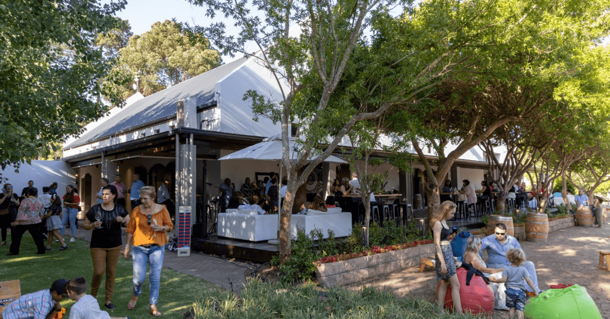 Guests enjoying an outdoor event at D'Aria Winery surrounded by trees and gardens